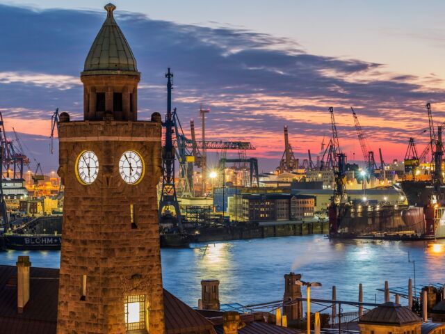 Ein Kirchenturm in Hamburg in der nacht, direkt neben dem Hafen